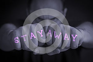 STAY AWAY written on an angry manÃ¢â¬â¢s fists photo